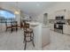 Modern kitchen features an island with bar seating, tile floors, and stainless steel appliances at 2928 Seasons Blvd, Sarasota, FL 34240