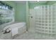 Bright main bathroom featuring a soaking tub, glass block shower, and tiled flooring at 2928 Seasons Blvd, Sarasota, FL 34240