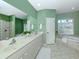Spa-like bathroom with dual sinks, a large mirror, and a separate bathtub and shower at 2928 Seasons Blvd, Sarasota, FL 34240