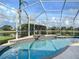Screened pool with spa, rock feature, and water views on a sunny day at 2928 Seasons Blvd, Sarasota, FL 34240