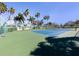 Community tennis court is surrounded by lush landscaping and well-maintained fencing at 2928 Seasons Blvd, Sarasota, FL 34240