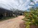 A unique stone exterior with a gravel driveway and mature landscaping at 3016 17Th St., Sarasota, FL 34234