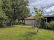 Large backyard with lush grass, a chain-link fence, and mature trees for privacy at 3139 Point St, North Port, FL 34286