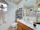 Well-maintained bathroom with a combination toilet and sink, shelving, and natural light from an adjacent window at 3139 Point St, North Port, FL 34286