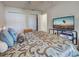 Spacious bedroom with stylish bedspread, large closet space, and a sleek entertainment center with a modern TV at 3139 Point St, North Port, FL 34286