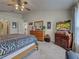 A cozy bedroom featuring a dresser, TV, carpet flooring, and an adjoining arched doorway at 3139 Point St, North Port, FL 34286