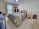 Comfortable bedroom with a decorative bedspread, natural light from the window, and classic furnishings at 3139 Point St, North Port, FL 34286