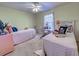 Inviting bedroom with two twin beds, desk, and a ceiling fan creating a comfortable and stylish space at 3139 Point St, North Port, FL 34286