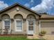 Close-up of front entrance with decorative arches, neutral exterior, and an attached garage at 3139 Point St, North Port, FL 34286