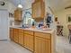 This kitchen has light wood cabinets, mosaic tile backsplash, and a double sink beneath a window at 3139 Point St, North Port, FL 34286