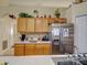 Bright kitchen featuring light wood cabinets, stainless steel refrigerator, and tile backsplash at 3139 Point St, North Port, FL 34286
