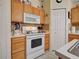 Kitchen featuring white oven and ample storage with a walk-in pantry and light wood cabinets at 3139 Point St, North Port, FL 34286