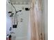 Clean white shower with adjustable shower head, built-in shelving, and decorative shower curtain at 3139 Point St, North Port, FL 34286