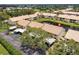 Aerial view of condo complex with a peaceful pond and convenient covered parking at 330 Mission N Trl # B, Venice, FL 34285