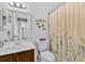 Bright bathroom features floral shower curtain and updated sink and toilet at 330 Mission N Trl # B, Venice, FL 34285