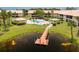 Beautiful community pool with a small dock on the pond and well-maintained landscaping at 330 Mission N Trl # B, Venice, FL 34285