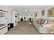 Bright living room with neutral carpet, ceiling fan, and seamless flow to the dining area at 330 Mission N Trl # B, Venice, FL 34285