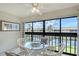 Enclosed balcony with tranquil water views, seating for four, and overhead lighting at 330 Mission N Trl # F, Venice, FL 34285