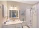 Bright bathroom with white vanity, framed mirror, and tub-shower combination with starfish accents at 330 Mission N Trl # F, Venice, FL 34285