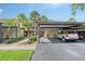 Assigned carport parking near the home with well maintained landscaping and tropical trees at 330 Mission N Trl # F, Venice, FL 34285