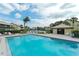 Community pool with sun loungers, palm trees, and a pool house for relaxation at 330 Mission N Trl # F, Venice, FL 34285