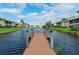 Scenic view from a wooden community dock overlooking the pond and surrounding tropical landscaping at 330 Mission N Trl # F, Venice, FL 34285