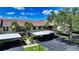 Exterior view of the home featuring covered parking, lush landscaping, and tile roof at 330 Mission N Trl # F, Venice, FL 34285