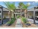Charming condo exterior with tropical landscaping, palm trees and convenient covered parking at 330 Mission N Trl # F, Venice, FL 34285
