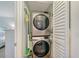 Efficient laundry closet featuring a stacked washer and dryer to maximize space-saving convenience at 330 Mission N Trl # F, Venice, FL 34285