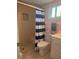 Tiled bathroom featuring a walk-in shower with a blue-striped curtain at 3697 Lake Bayshore Dr # H-109, Bradenton, FL 34205