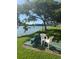 Inviting lakeside bench and chair seating, nestled under a large shade tree at 3697 Lake Bayshore Dr # H-109, Bradenton, FL 34205