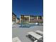 Community pool with lounge chairs and clear blue sky background at 3697 Lake Bayshore Dr # H-109, Bradenton, FL 34205