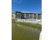 Waterfront buildings featuring a pool area enclosed by a white fence and palm trees at 3697 Lake Bayshore Dr # H-109, Bradenton, FL 34205