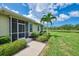Exterior of a home with a screened lanai, well-maintained lawn, and serene pond view at 371 Capulet Dr, Venice, FL 34292