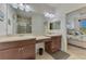 Bathroom featuring dual sinks, large mirror, and access to the bedroom and glass shower at 371 Capulet Dr, Venice, FL 34292