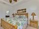 Bright primary bedroom features king bed, bamboo furniture, and tropical-themed decor for a tranquil retreat at 371 Capulet Dr, Venice, FL 34292