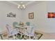 Light-filled dining area shows coastal decor with glass table, wicker chairs, and marine themed wall art at 371 Capulet Dr, Venice, FL 34292