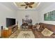 Cozy living room with ceiling fan, television, desk, and comfortable seating at 371 Capulet Dr, Venice, FL 34292