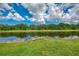 Scenic view of a serene pond reflecting the blue sky and lush greenery surrounding the property at 371 Capulet Dr, Venice, FL 34292