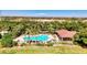 Aerial view of a sparkling community pool, surrounded by palm trees, lounge chairs, and lush greenery at 371 Capulet Dr, Venice, FL 34292