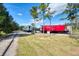 Red and silver train cars are seen on the tracks surrounded by green grass and trees on a sunny day at 371 Capulet Dr, Venice, FL 34292