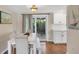 Bright dining area with a white table, chairs, bench and sliding glass doors to backyard at 386 Nightingale Rd, Venice, FL 34293