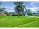 Well-kept single-story home with a large palm tree accenting the front lawn, enhanced by mature landscaping at 386 Nightingale Rd, Venice, FL 34293