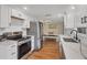 Modern kitchen featuring stainless steel appliances, white cabinetry, and granite countertops, ideal for culinary enthusiasts at 386 Nightingale Rd, Venice, FL 34293