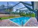 Fenced in-ground pool with screened enclosure and brick paver deck, with a cozy outdoor living area at 386 Nightingale Rd, Venice, FL 34293