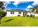 Beautiful backyard featuring lush green grass, landscaping, and a patio with seating area and solar panels at 4033 Union Ln, North Port, FL 34288