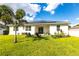 Inviting backyard showcasing lawn, a patio with seating, well-maintained landscaping and solar panels at 4033 Union Ln, North Port, FL 34288