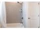 Bathtub with a gray tiled wall featuring a shower head at 4033 Union Ln, North Port, FL 34288