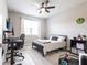 Bright bedroom features a black bed frame, desk and ceiling fan at 4033 Union Ln, North Port, FL 34288