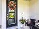 Front door adorned with wreath, with a cozy sitting area to the side at 4033 Union Ln, North Port, FL 34288